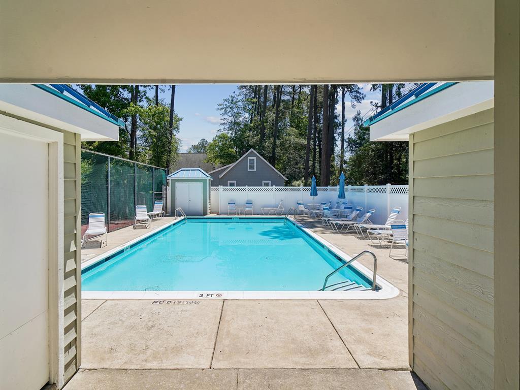 image Community pool with lounge chairs and shade umbrellas -- cool off between beach days