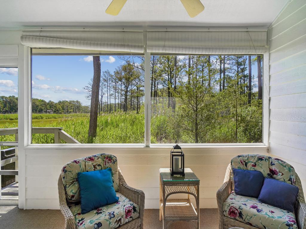 image Two wicker chairs with floral cushions on the screened-in porch, overlooking the greenery outside