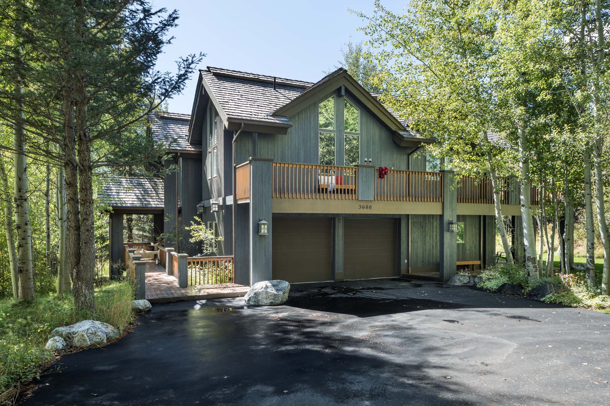 image Timber siding and large windows front this two-level mountain home.