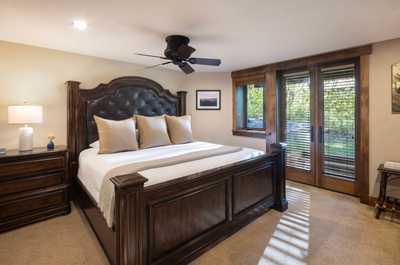 Plush linens dress the king bed, set against timber furnishings and natural light.