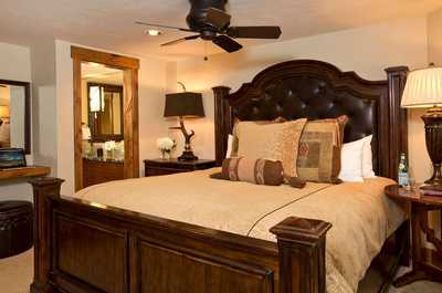 Warm-toned linens dress the king bed, set against timber furnishings and natural light.