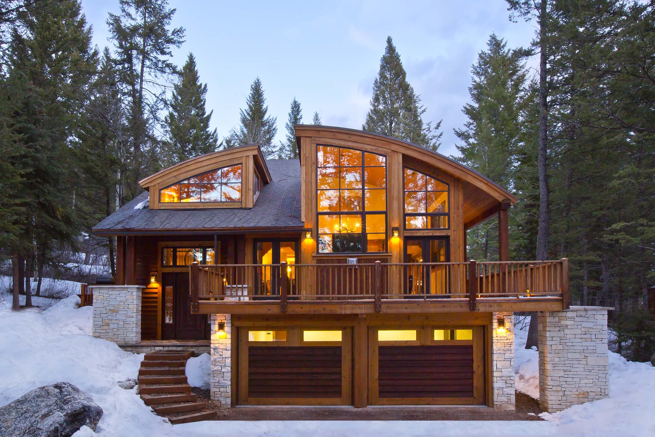 image A wrap-around deck and double garage wrap the exterior of the three-floor lodge.
