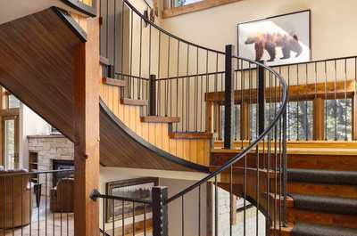 Custom artwork lines the walls beside the signature spiral staircase.