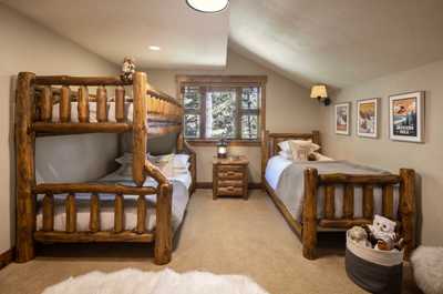 Log furniture frames the double bed and twin bunks, giving kids their own space to sleep.