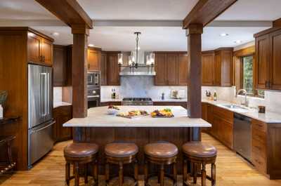 Prepare meals at the kitchen island, backed by wood cabinetry and full-size appliances.