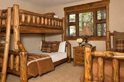 Log furniture frames the double bed and twin bunks, giving kids their own space to sleep.