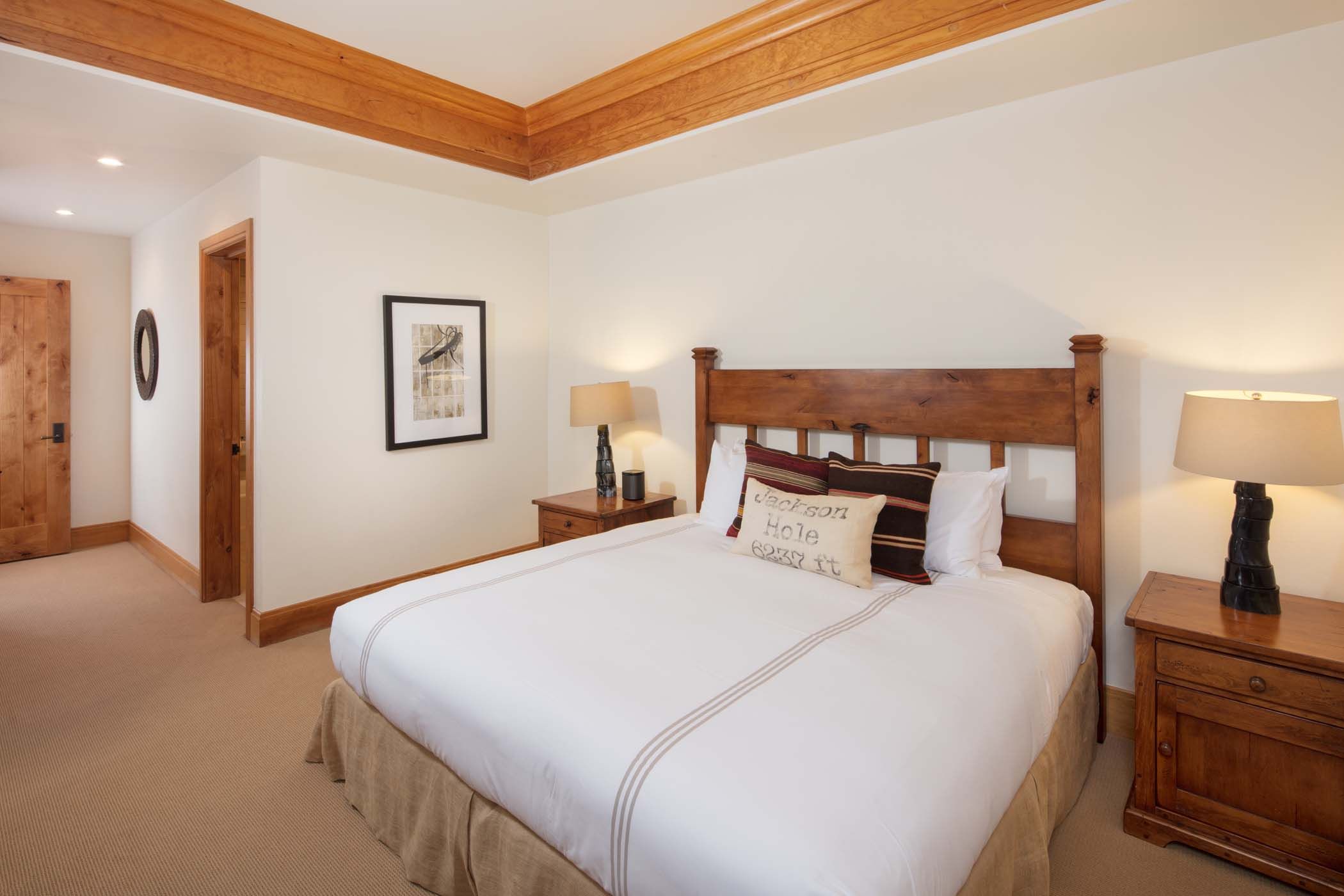 image A wood-framed bed with a Jackson Hole accent pillow furnishes this guest bedroom.