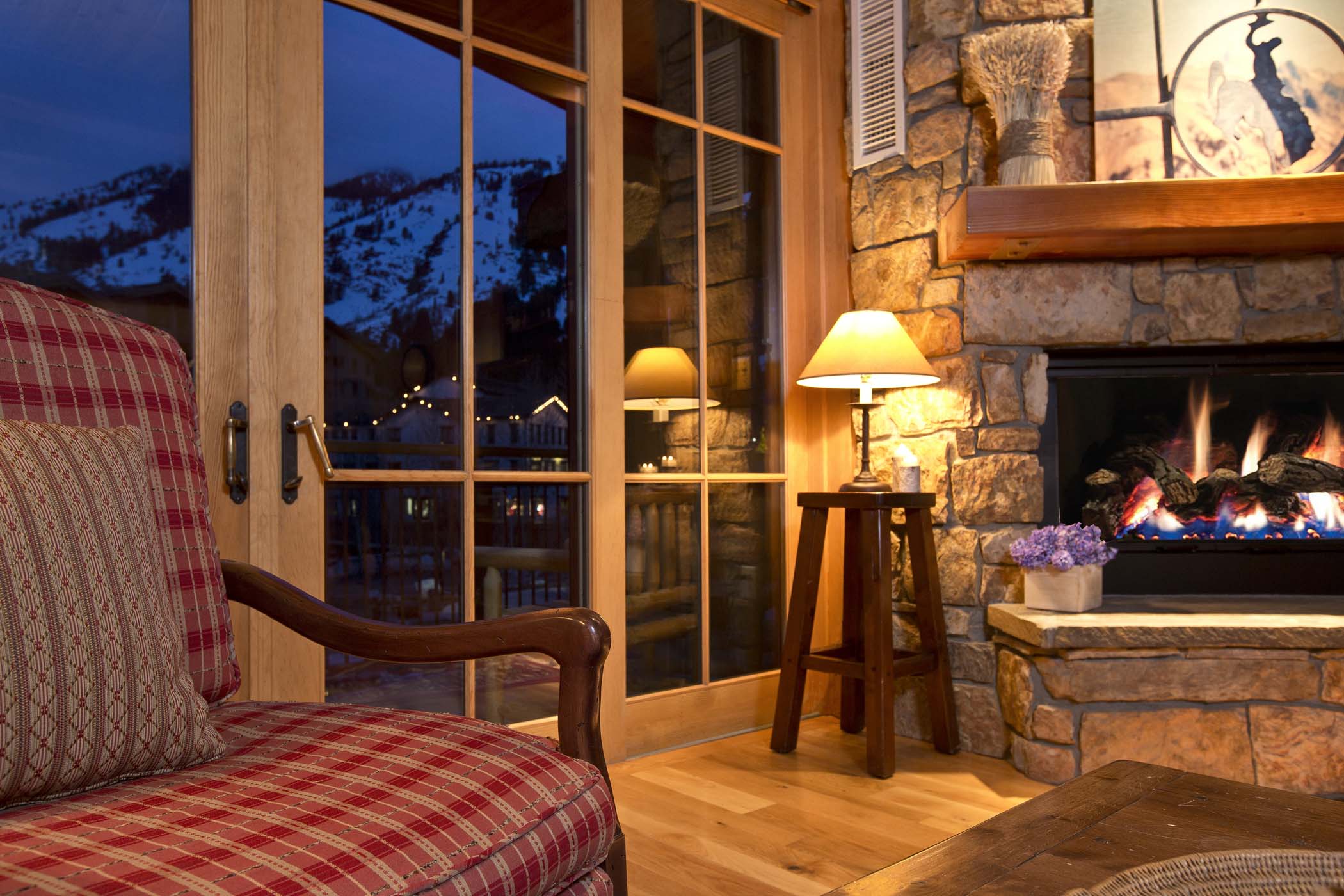 image Soft lamp light warms the seating area beside the fireplace.