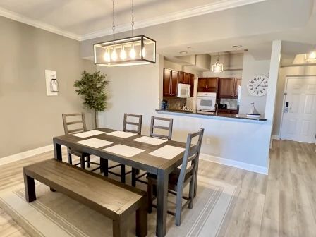 image Dining area with a large wooden table and seating for six, open to the kitchen