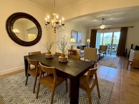 image Dining area with a dark wood table and chandelier, seats the whole group