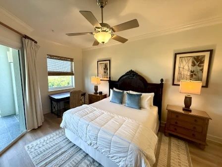 image King bedroom with wooden furniture and private balcony access for ocean and golf views