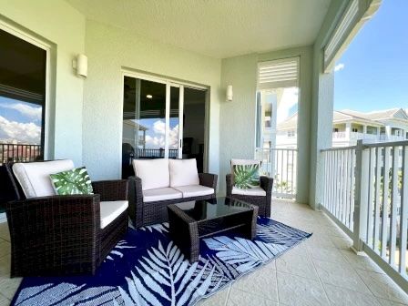 image Private balcony with two chairs and a table overlooking the ocean and blue sky