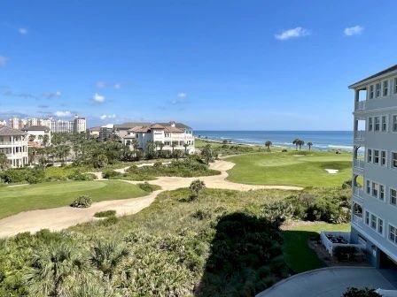 image View from the private balcony — green golf course, palm trees, and the Atlantic stretching beyond