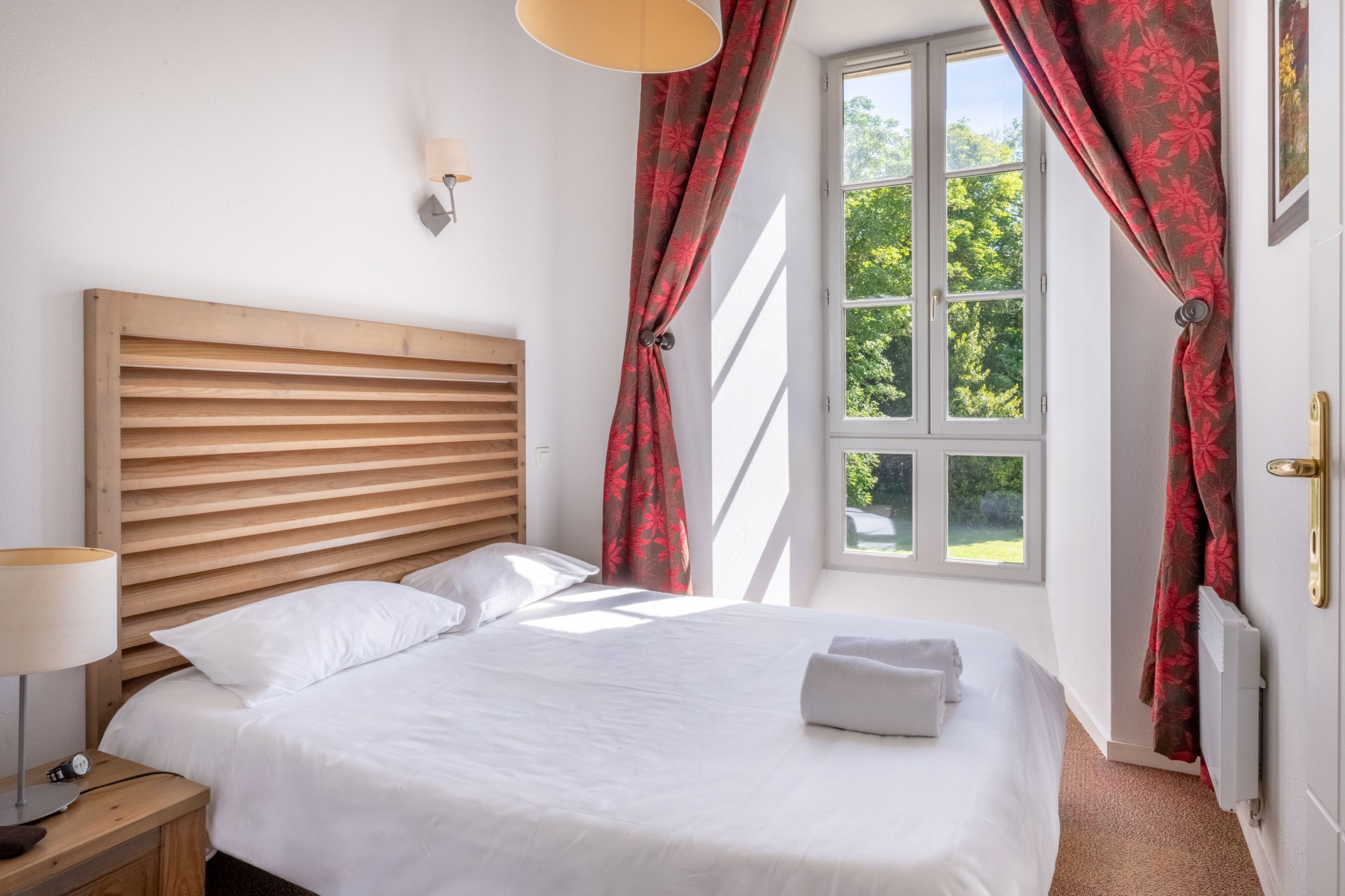 image Wake up in the sun-lit bedroom, framed by a wooden headboard and crisp linens.