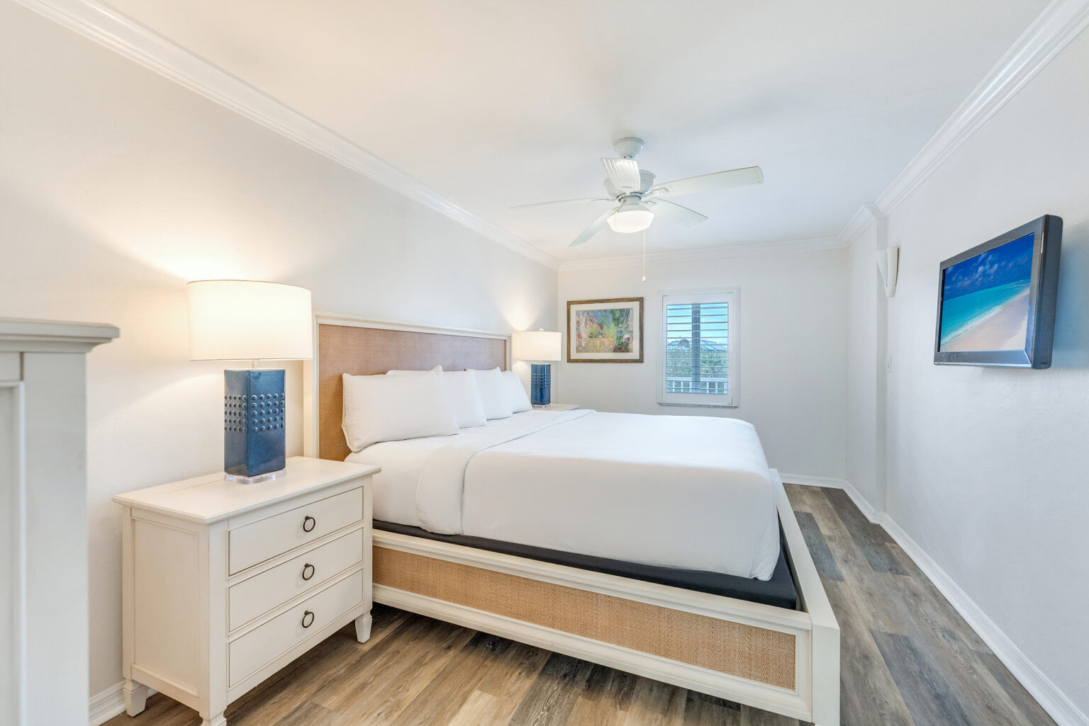 image The bedroom features a bed beneath a ceiling fan, with decor in soft tones.