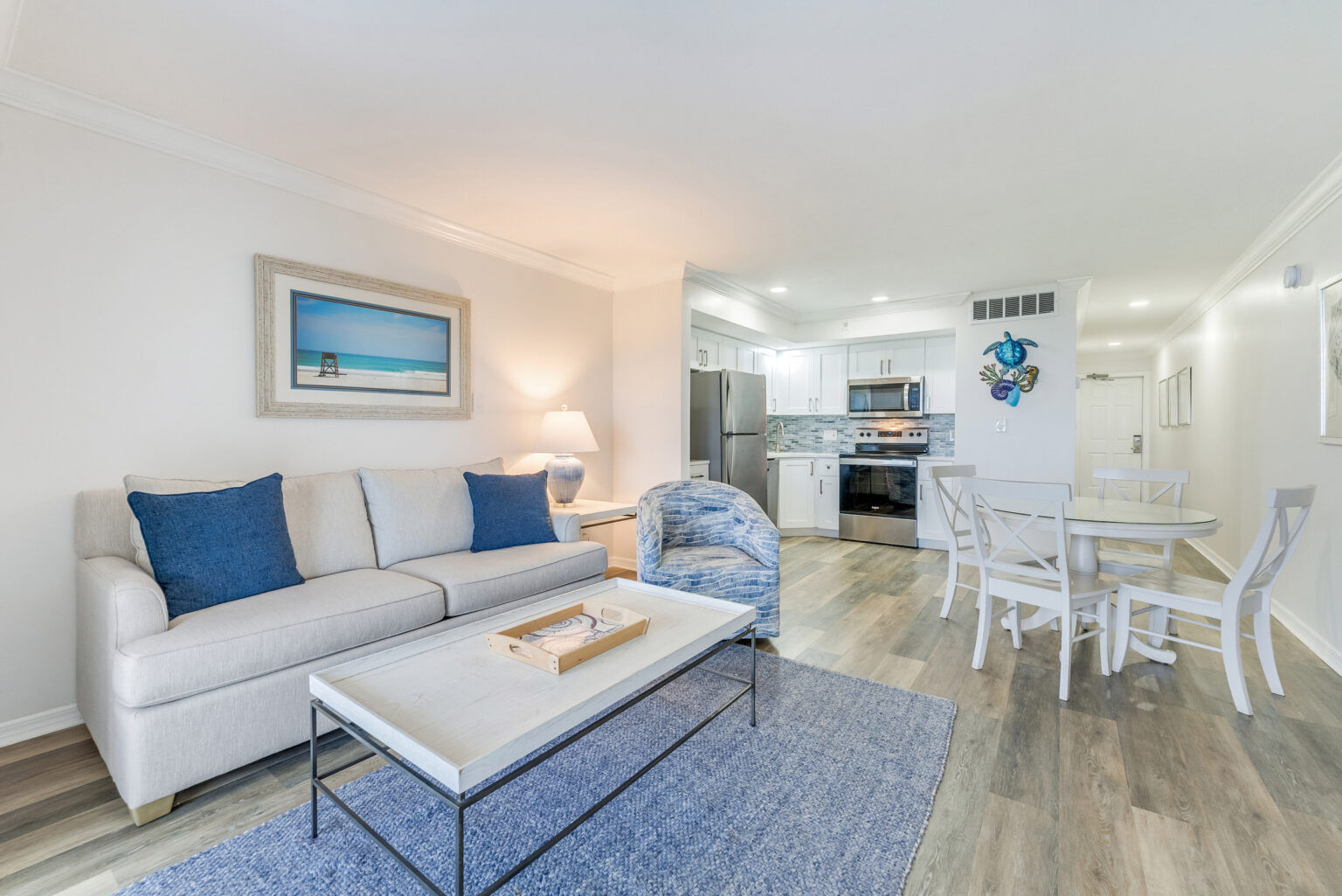 image A dining table, couch, chair, and refrigerator share this open living and dining area.