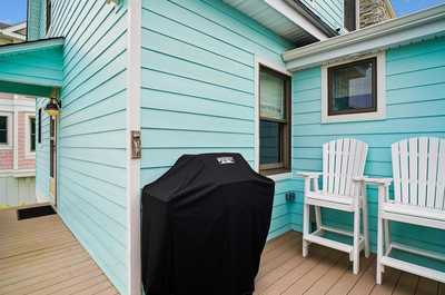 Barbecue grill and outdoor chairs ready for warm-evening cookouts on the deck.