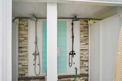 Outdoor shower mounted on a light blue wall with a clean, simple design.