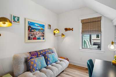 Compact room with a sofa, wall art, and a casual work surface.