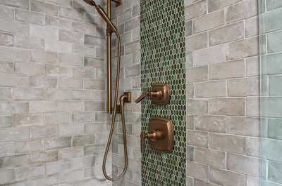 Walk-in shower with patterned tile walls and a sleek rainfall showerhead.