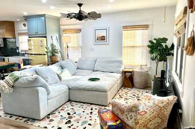Warm living space with plush seating, cheerful decor, and natural light streaming through.