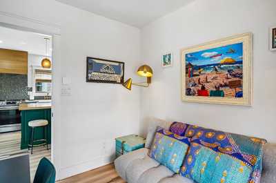 Sitting area with colorful throw pillows and ocean-inspired art on the walls.