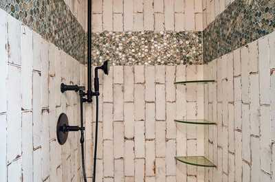 Shower with dark stone tiles and a sleek black showerhead.