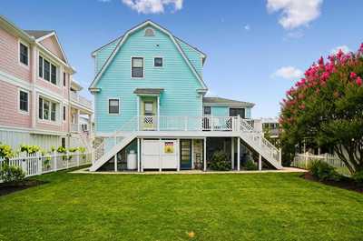 Rear of the house with a pastel exterior and inviting outdoor spaces.