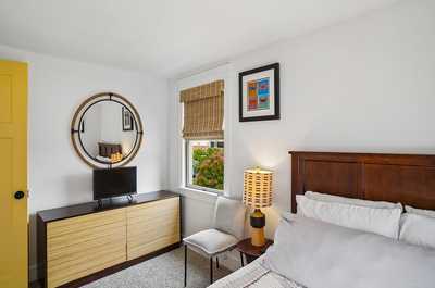 Bedroom with a round mirror, warm lamp, and a collection of wall decor.