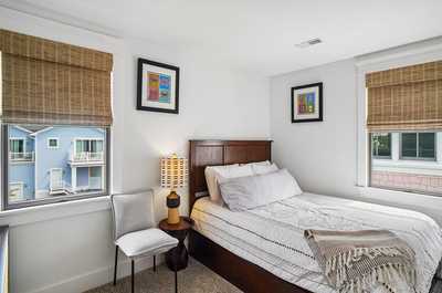 Bedoom with framed prints, a comfortable bed, and gentle natural light.