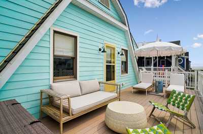 Outdoor deck with plush seating framed by cheerful turquoise-painted walls.