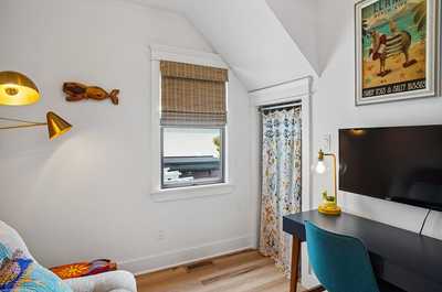 Peaceful study area with a desk, lamp, and wall-mounted TV.