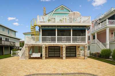 Multi-level home with a spiral staircase set in a leafy residential street.