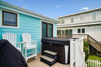 Patio with lounge chairs and a private hot tub tucked alongside.