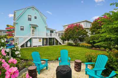 Lush garden seating area backed by colorful blooms and a green hedge.
