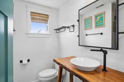 Crisp bathroom with a rustic wooden vanity and modern matte black fixtures.
