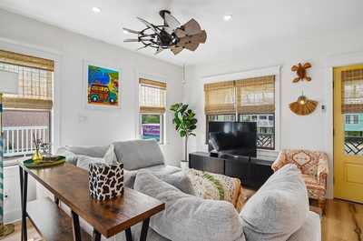Relaxed living area punctuated by wall art and greenery, with a homey feel.