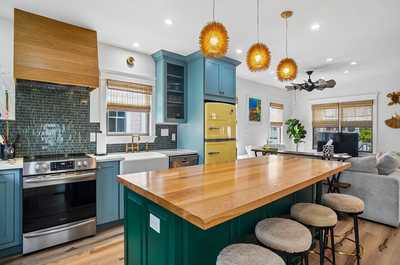 Open kitchen with a central island flowing into the bright living area.