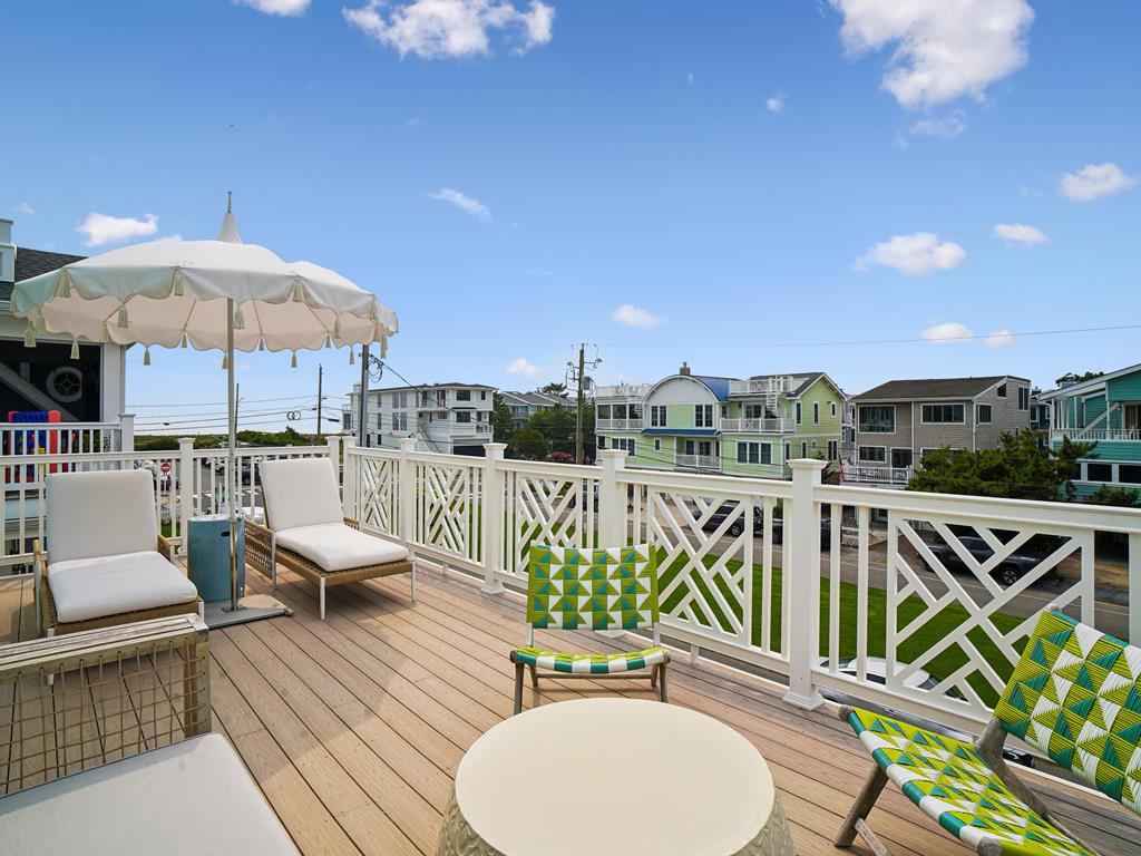 image Colorful outdoor seating area overlooking a lively, sun-filled neighborhood street.