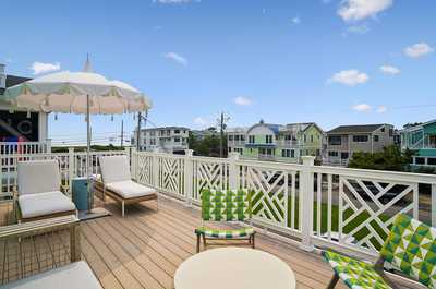 Colorful outdoor seating area overlooking a lively, sun-filled neighborhood street.