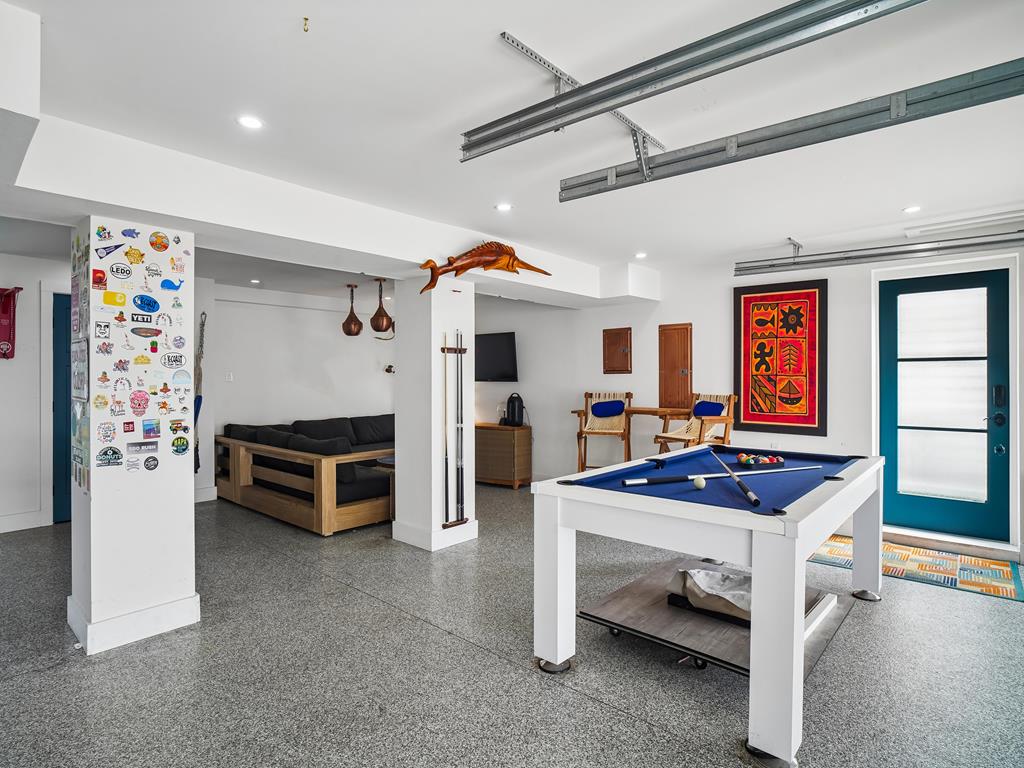 image Spacious lounge with a sectional sofa, round table, and warm pendant lights.
