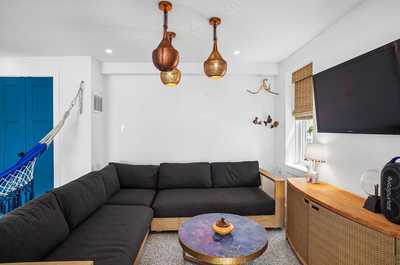 Ground-level games room with a pool table and casual wicker chairs.