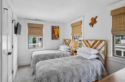 Bedroom with two single beds, a wall-mounted TV, and views of the yard.