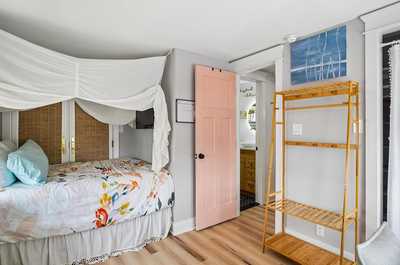Cozy sleeping nook with floral bedding and a vibrant painted door.