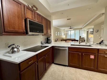 image Kitchen with dark wood cabinetry, granite counters, and full-sized stainless appliances