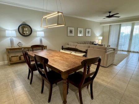 image Dining table with seating beneath a contemporary pendant light — open to the kitchen and living area