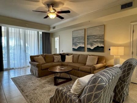 image Living area with plush sectional, natural light through sheer curtains, and waterway views beyond