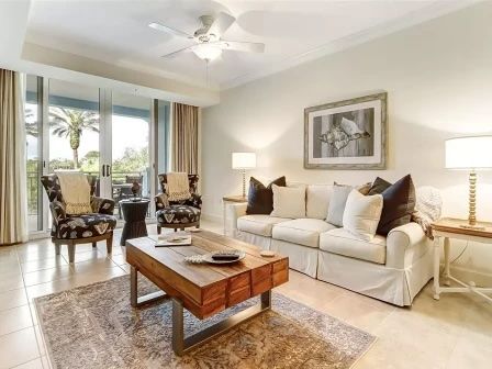 image Living area with a plush sofa, warm natural light, and large windows overlooking the water