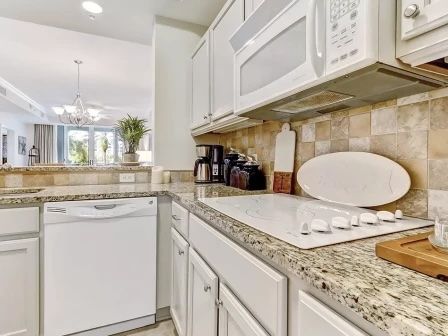 image Kitchen with granite counters, full-sized appliances, and a bar counter with four stools