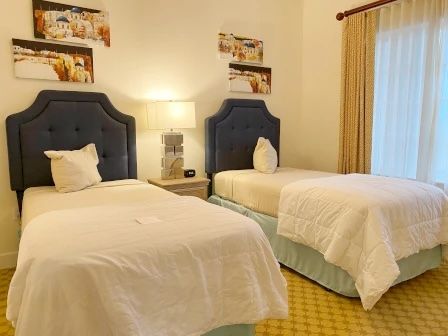 image Twin bedroom with two beds, playful decor, and morning light through the window
